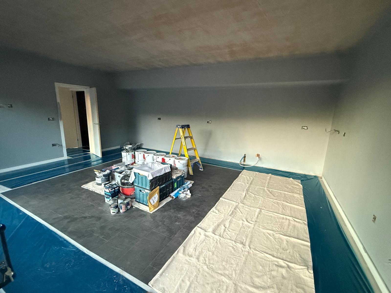 Interior being decorated with slate tiled flooring protected during painting