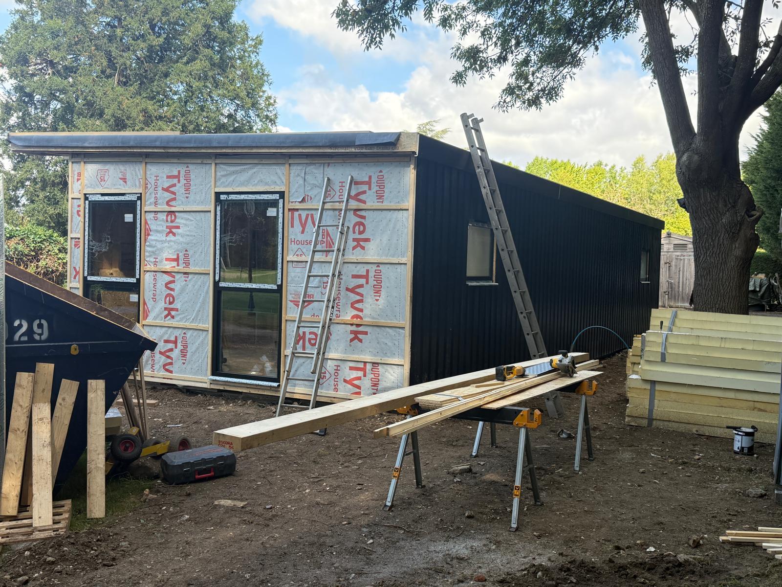 Black composite cladding being installed on the Thorpe annexe