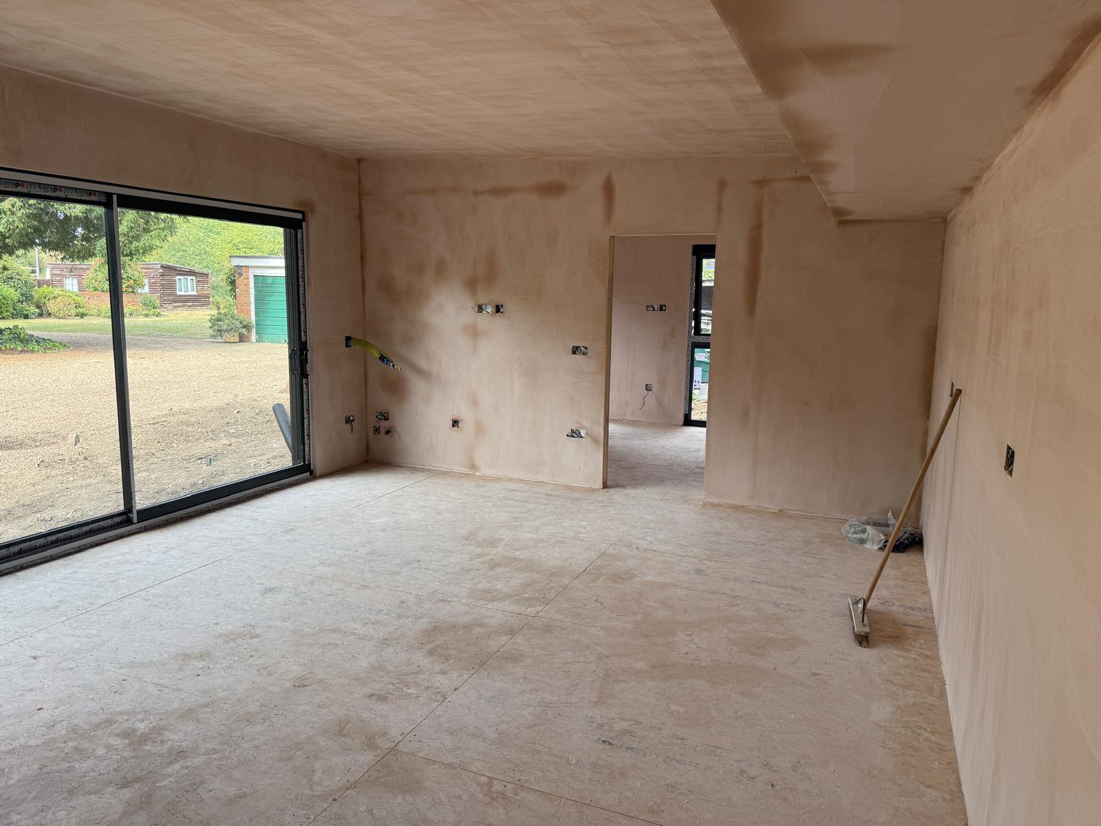 Plastered open-plan living space with sliding doors to the garden
